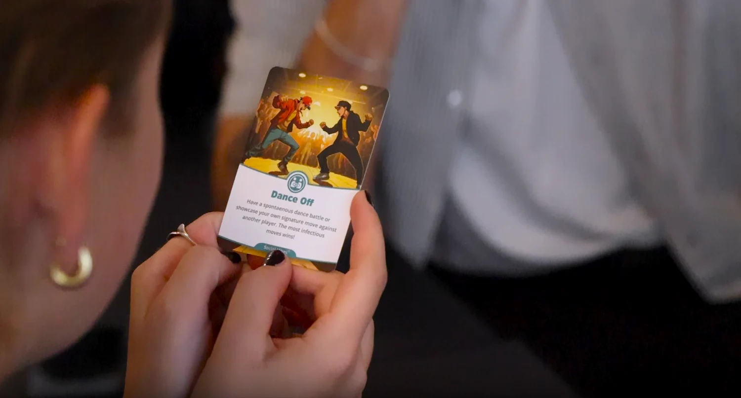 a picture of a girl holding the dance off card fomr the social shuffle card deck